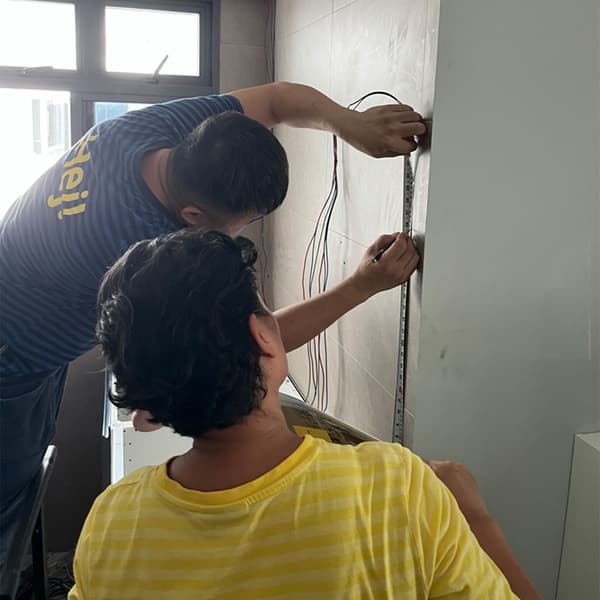 IKEA Kitchen Specialist Shikin doing on-site measurements with another IKEA co-worker