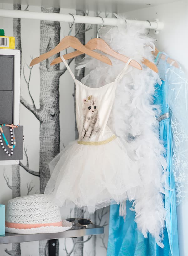 IKEA KOMPLEMENT white clothes rail with hangers that hold fancy children's dress outfits and accessories.