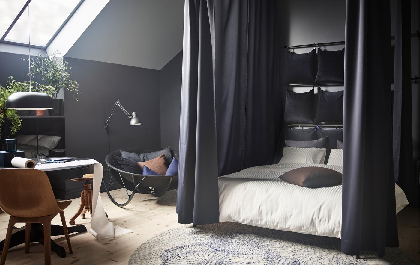IKEA 제품으로 아늑한 침대를 만들 수 있어요. 먼저, 침대프레임 주변 천장에 커튼레일을 설치해주세요. 파우더코팅 스틸 소재의 그레이 KOPPARDAL/코파르달 레일이 사용하기에 좋아요. 그다음 빛과 소음을 차단해주는 다크블루 색상의 SANELA/사넬라 코튼 벨벳 커튼을 달아주면 완성입니다!