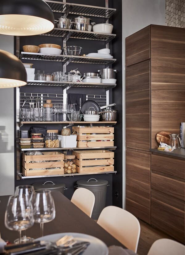 IKEA KUNGSFORS stainless steel open storage shelves storing KNAGGLIG pine boxes.