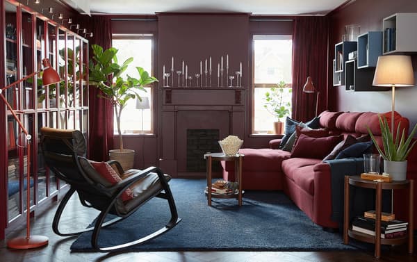 IKEA LIDHULT three-seater red and brown sofabed with long chaise in a red-walled living room.