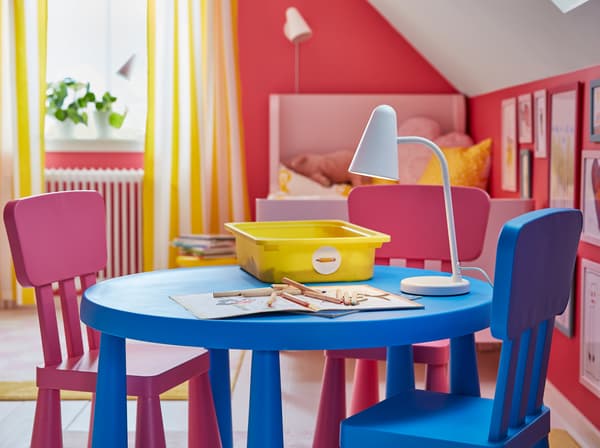 IKEA MAMMUT طاولة بلاستيكية بلون أزرق زاه وكراسي بها كرسي بلون وردي.