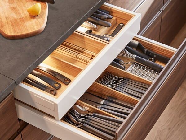 IKEA METOD kitchen drawers, open with cutlery in organised drawer inserts with installed lighting inside.