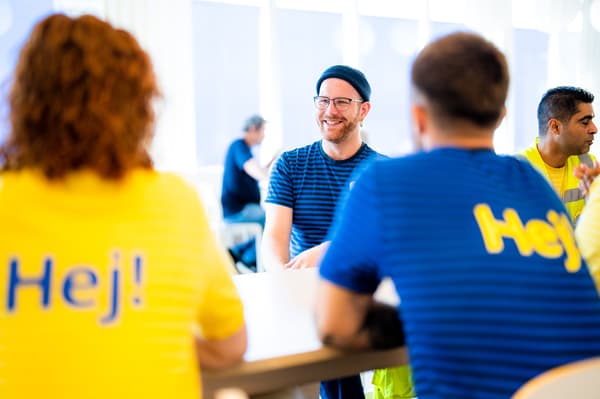 IKEA Mitarbeitende in dunkelblauen Uniformen stellen im Schwedenrestaurant Gerichte auf Tellern zusammen.
