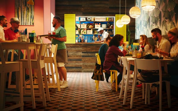 IKEA NORRÅKER white birch bar tables and birch bar stools in a small restaurant with INDUSTRIELL bamboo pendant lamps.