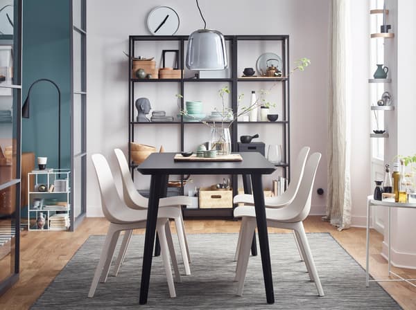 IKEA ODGER recycled plastic white chairs and black LISABO table, arranged in a dining area space.