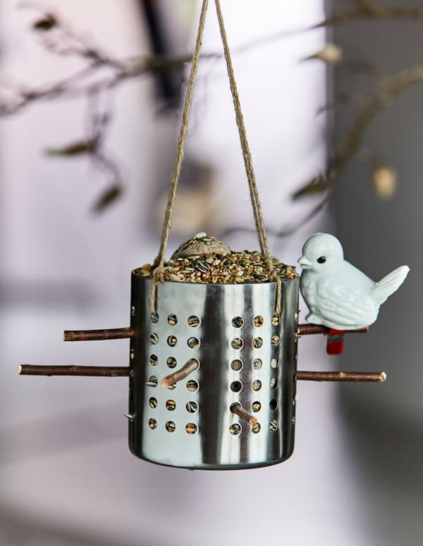 IKEA ORDNING bestikholder er fyldt med fuglefrø og hængt op som fuglefoderbræt.