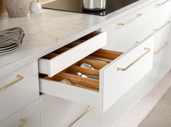 IKEA RINGHULT high gloss white drawer fronts with gold BAGGANÄS handles.