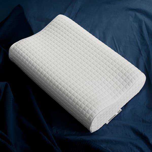 다크블루 색상의 침구 위에 놓인 템퍼 모양의 IKEA ROSENSKÄRM 로센셰름 인체공학적 베개