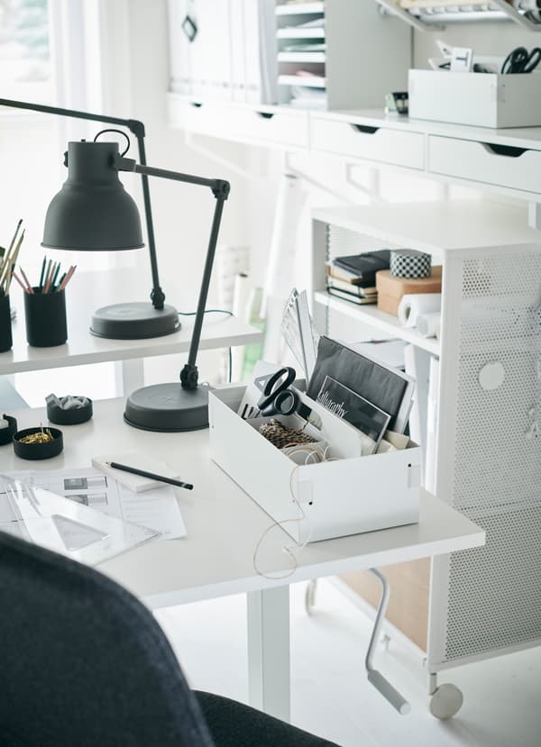 IKEA SKARSTA white sit and stand desk has a crank handle underneath the table to adjust and customise the height.