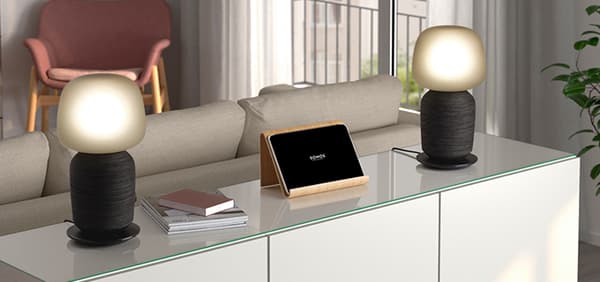 IKEA Smart Speaker mit Lampe auf einem Besta REgal vor einer couch,