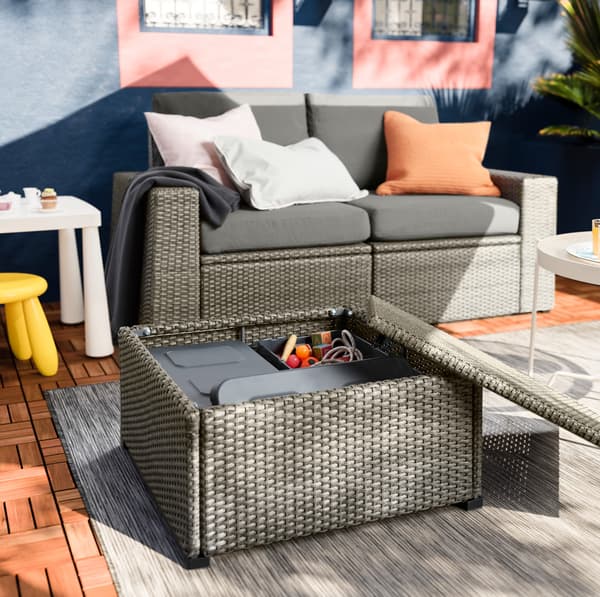 IKEA SOLLERÖN footstool with storage compartment lid open to show KLÄMTARE dark grey weatherproof boxes storing toys.