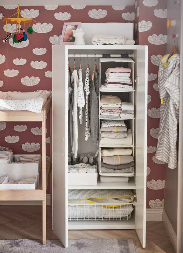 IKEA STUVA FRITIDS white wardrobe with clothes rail and shelf inside organising baby clothes.