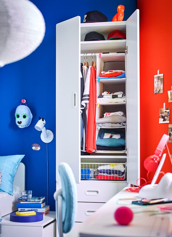 IKEA STUVA white wardrobe with RASSLA hanging storage organiser and folded clothes.
