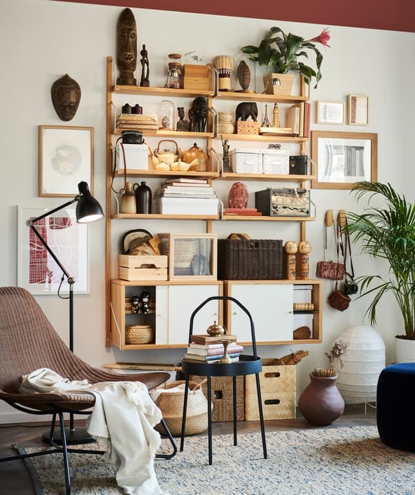 IKEA SVALNÄS shelving on a wall in a living room decorated with travel souvenirs.