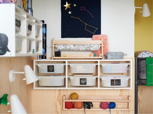 IKEA TROFAST 6-drawer toy storage unit mounted to the wall in a children's room, with black handwritten labels.