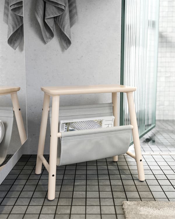IKEA VILTO stool in birch that's standing outside the bathroom and it stores magazines in the grey fabric.
