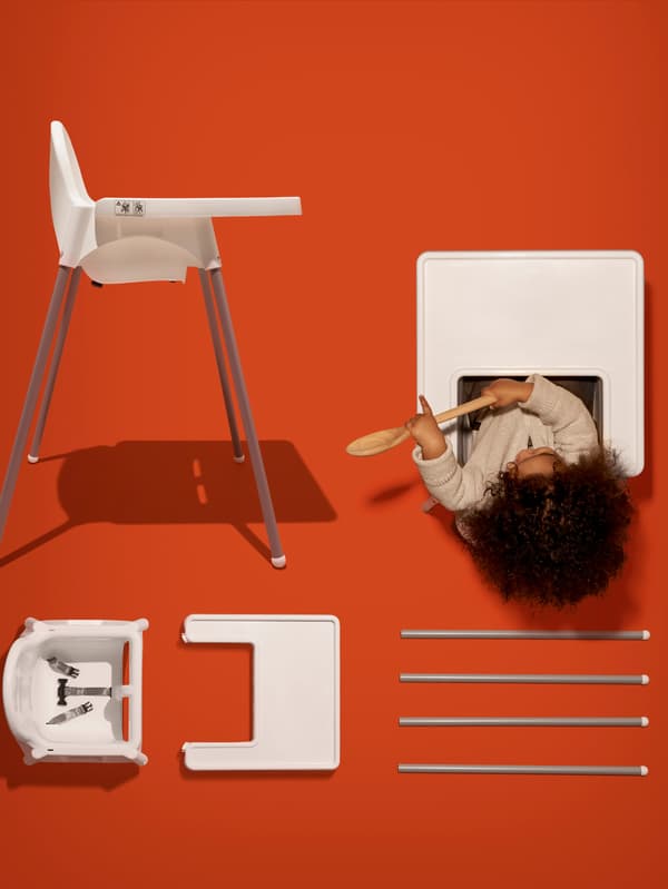 Il seggiolone ANTILOP mostrato per intero, con un bambino seduto, e smontato su uno sfondo arancione - IKEA