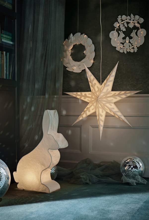 Illuminated LED paper lanterns in various shapes hanging in a room.