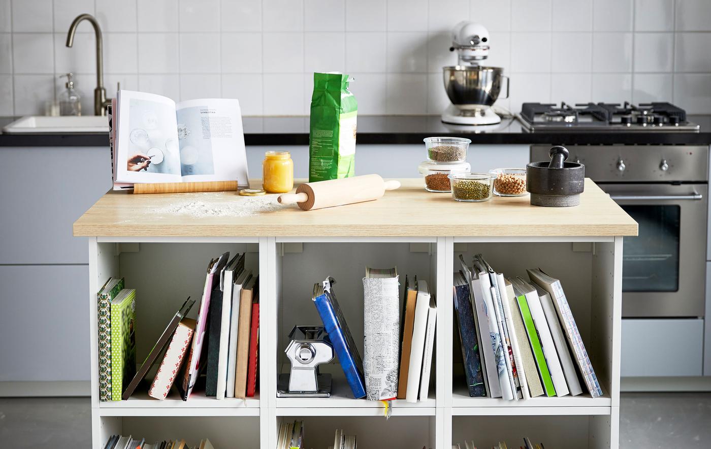 Îlot de cuisine avec plan de travail en bois et étagères intégrées. L’idéal pour faire de la pâtisserie et ranger ses livres de recettes.