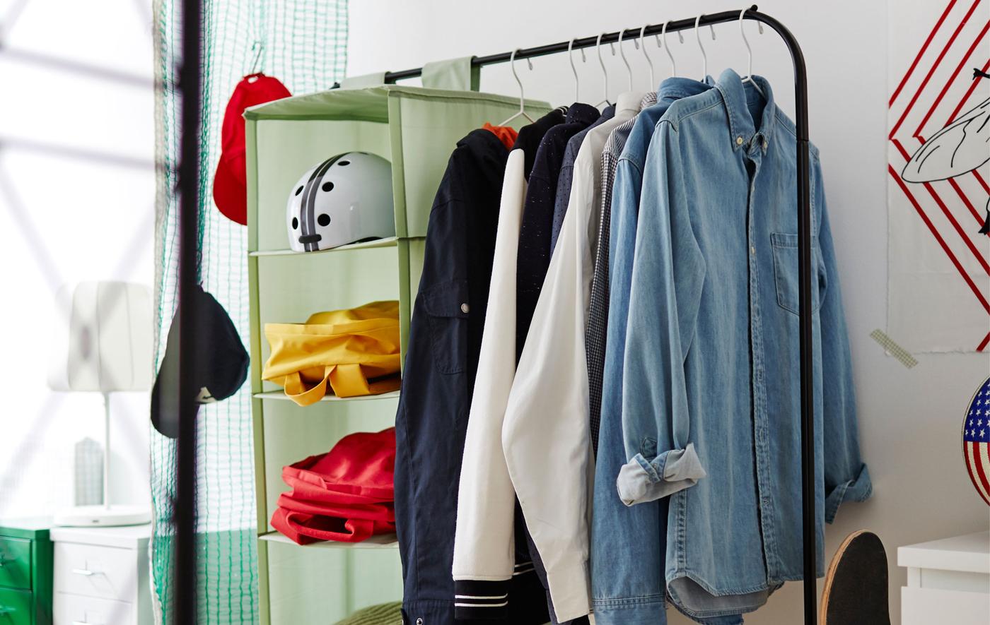 Image of a black clothes rail with shirts and a green organiser hanging from it