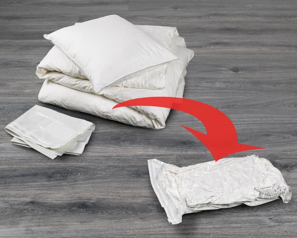 Image of a duvet and pillow, with a red arrow pointing to a vacuum sealed SPANTAD bag, showing SPANTAD's capacity.