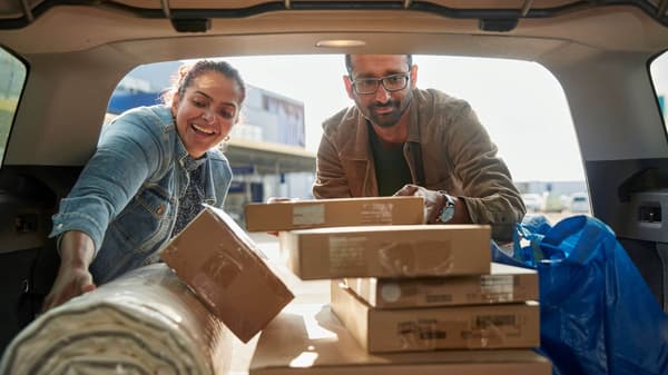Image of a man and women loading their IKEA purchases in the back of their car