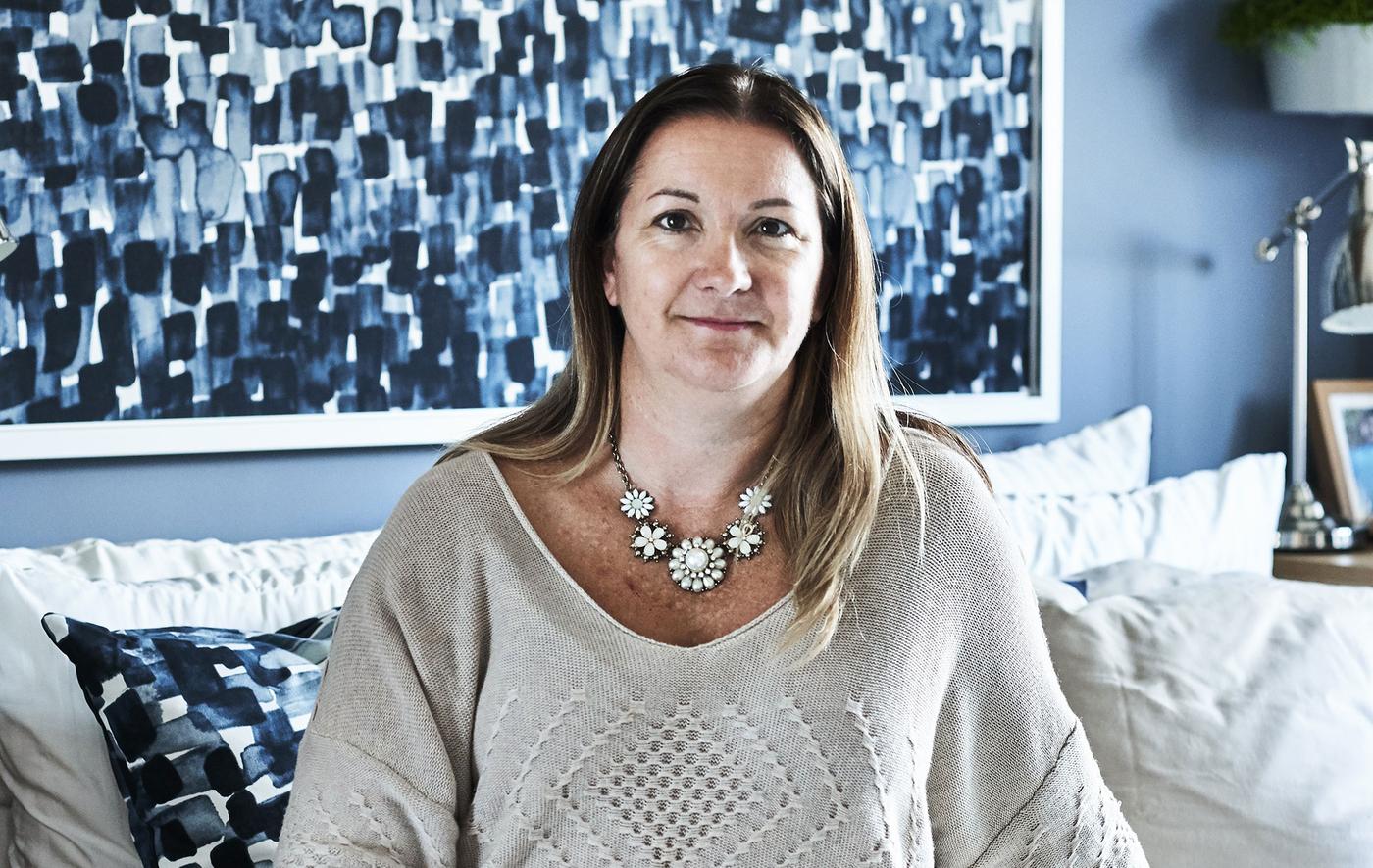 Image of Bekki sitting in her newly decorated bedroom in blues
