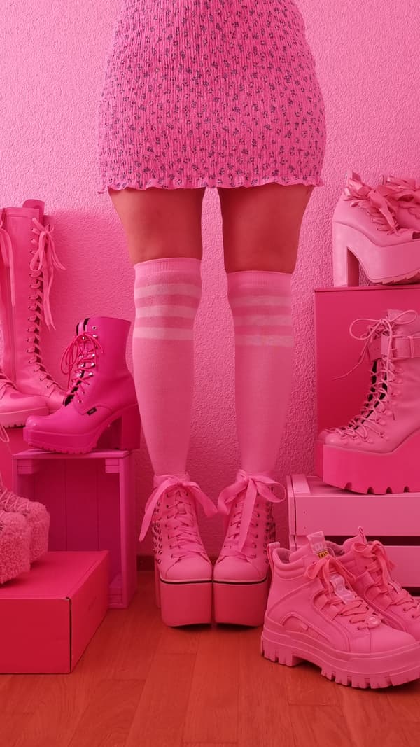 Immagine di gambe di donna con una gonna rosa. Calze al ginocchio rosa e scarpe rosa, circondate da altre scarpe rosa - IKEA.