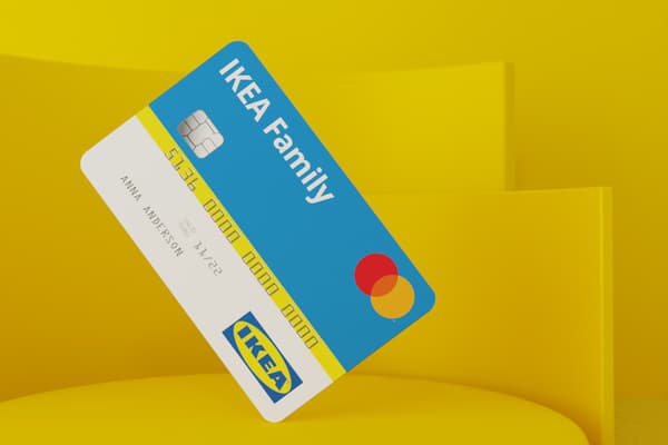 Immagine simbolica della carta di credito IKEA Family: una carta di credito bianca e blu con il logo IKEA su uno sfondo giallo astratto.