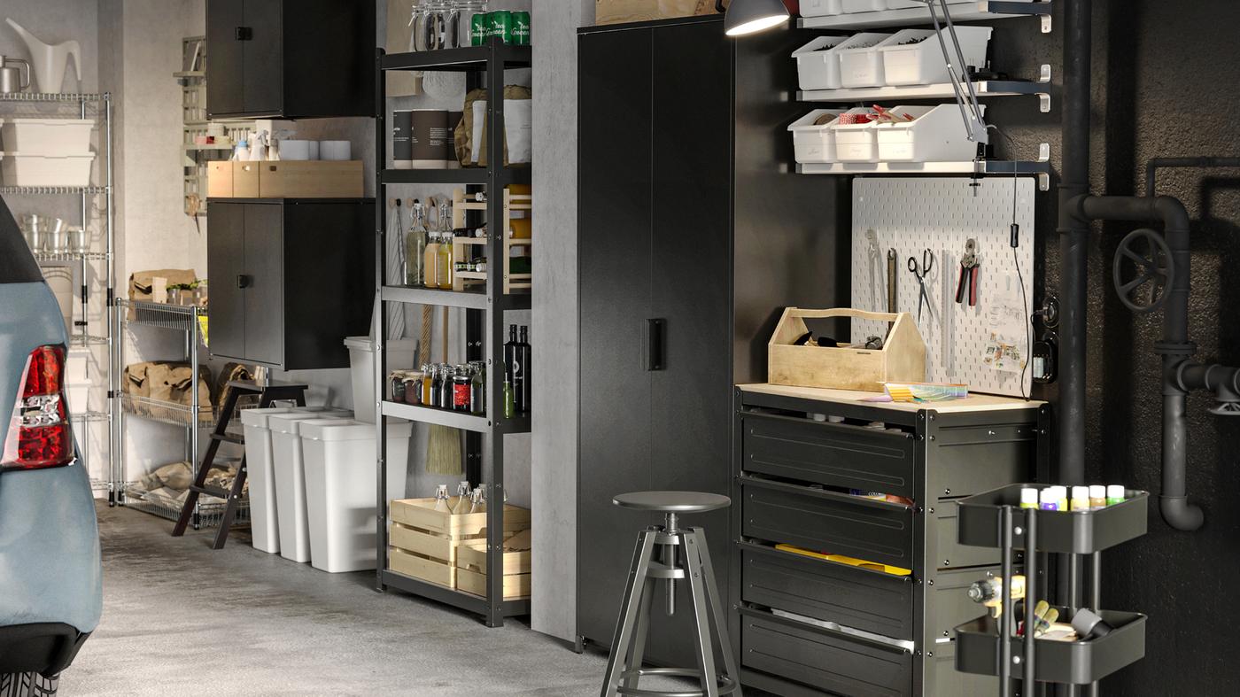 In a garage are black BROR open and closed storage cabinets. On the shelves are boxes and bottles. Underneath are recycling bins.
