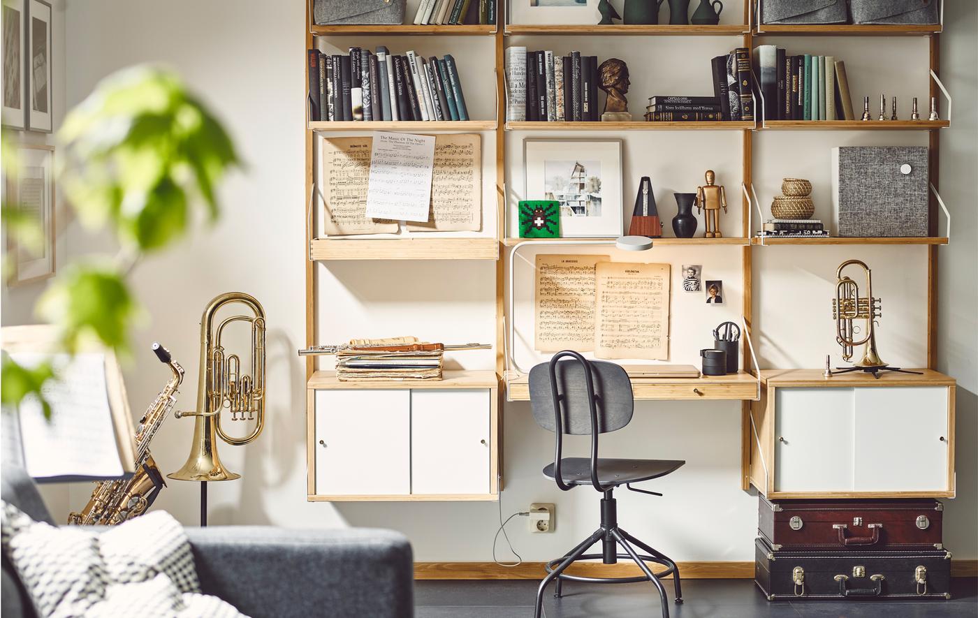 Instruments de musique, musique et livres disposés sur un rangement mural avec module bureau et armoires.