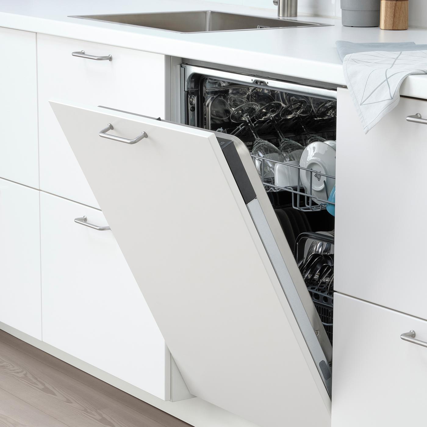 Integrated IKEA dishwasher in white modern kitchen that is open, showing clean plates and cups.