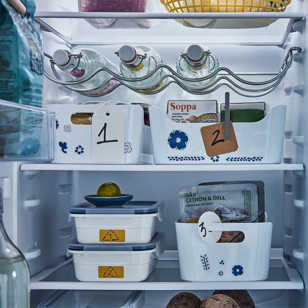 Intérieur de frigo avec différents récipients et boîtes dont certains sur les étagères sont pourvus de numéros.