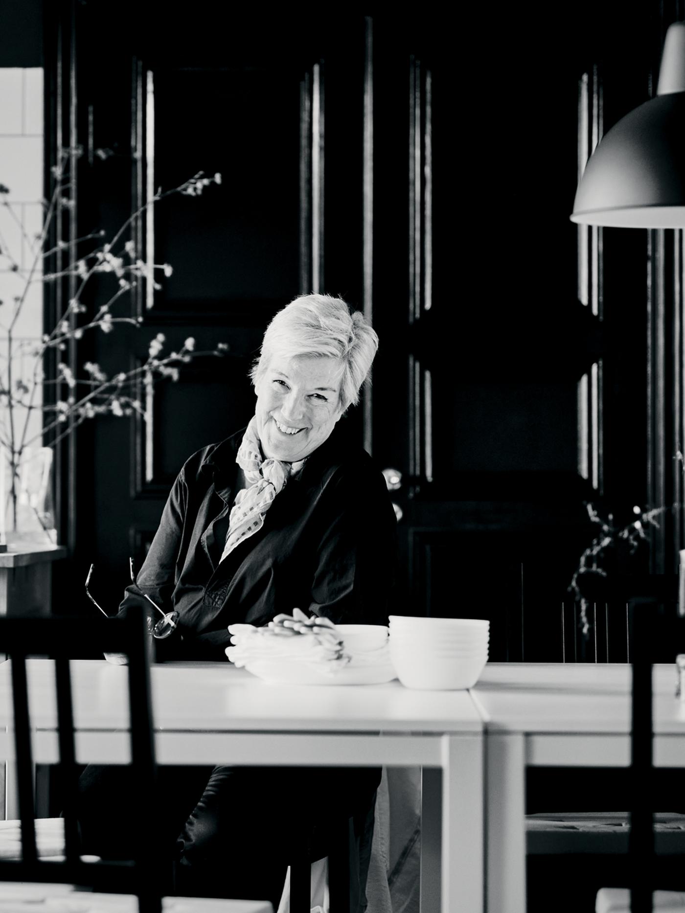 Interior designer Mia Gustafsson sitting at a dining area formed by two MELLTORP tables and STEFAN chairs.