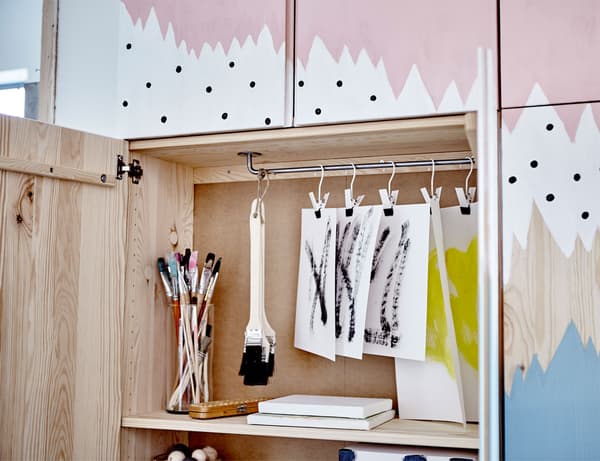 IVAR cabinets with a painted mural on them in blue, white and pink. Opened up to show storage space inside.