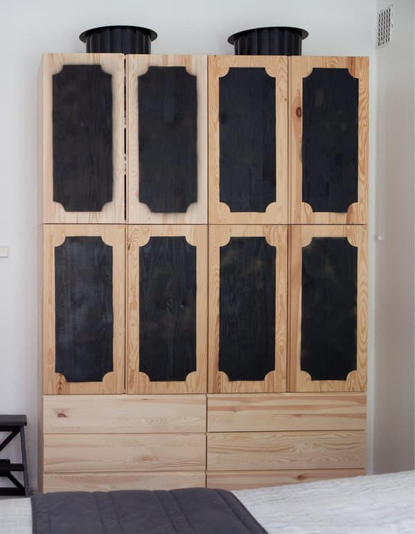 IVAR utilisé comme armoire, avec quatre éléments posés sur deux commodes 3 tiroirs et portes bombées en noir.