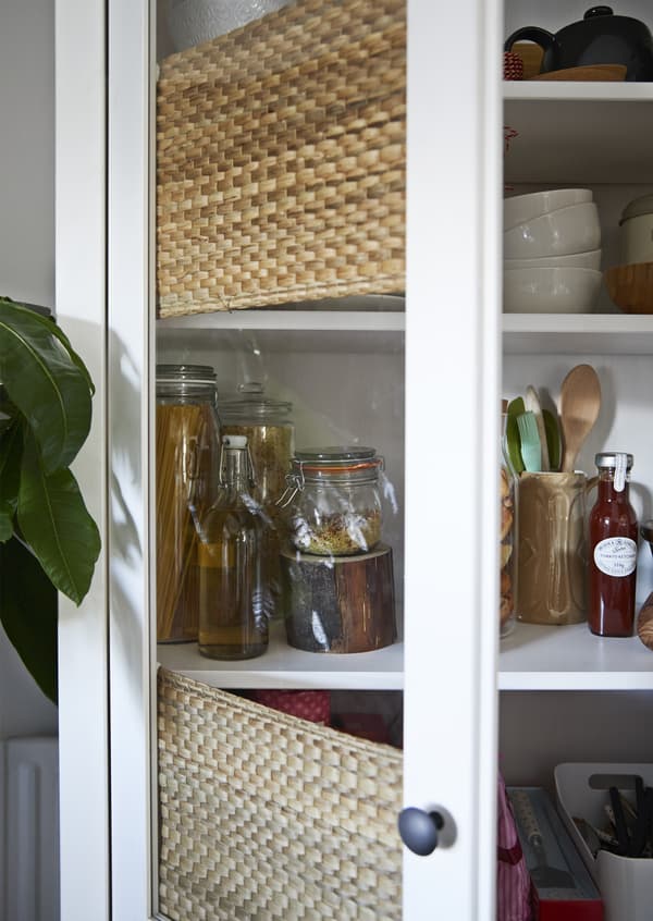 Jars and utensils stored in a cupboard.