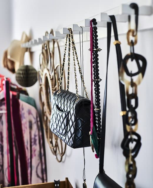 Jewellery and bags hanging on a row of hooks.