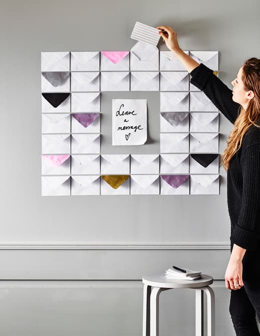 Joli babillard créé d’enveloppes fixées au mur, papier coloré placé à proximité 
