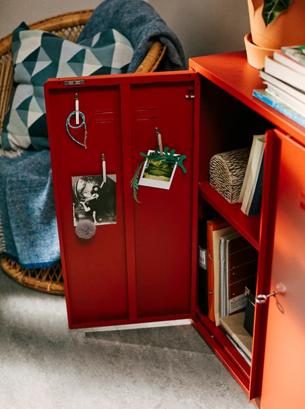 Kabinet IVAR berwarna merah terletak di dalam bilik tidur pelajar, dengan salah satu pintu terbuka menunjukkan foto filem yang dipamerkan di bahagian dalam.