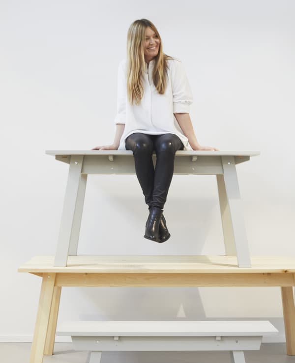 Karin Gustavsson sitting on a stack of benches.