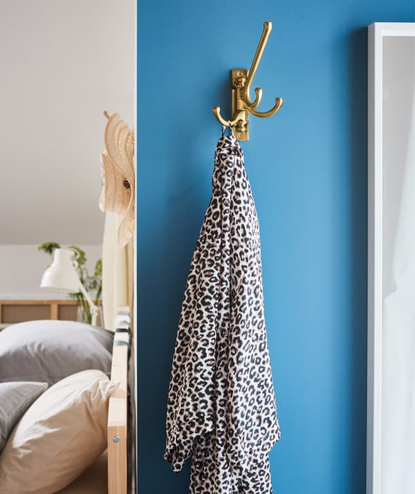 Keep your bedtime necessities close to you by hanging them on a hook, such as IKEA KÄMPIG brass-coloured 3-armed swivel hook.