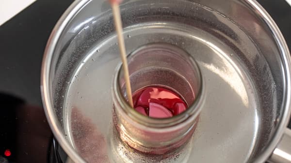 Kerzenreste werden in einem Glas im Wasserbad geschmolzen