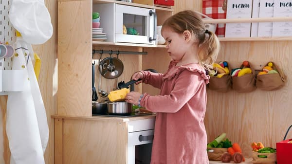 Kid playing on DUKTIG play kitchen.