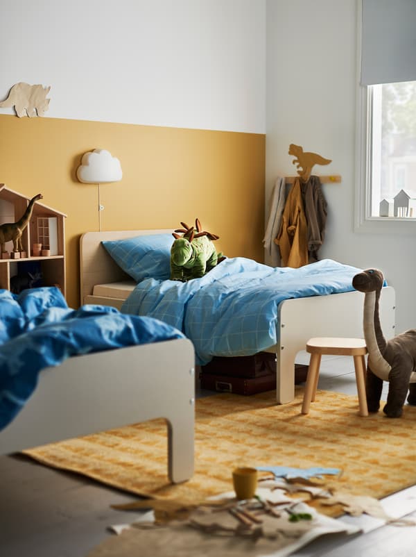 Kinderzimmer mit zwei SLÄKT Bettgestellen nebeneinander. Drumherum sind Spielzeug und Aufbewahrungen zu sehen.