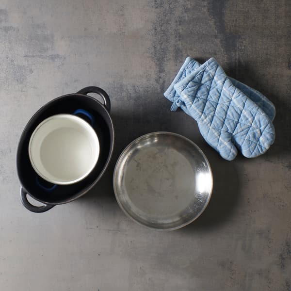 Kitchen utensils such as a pan, a bowl, and oven mitts are ready to go in preparation for a hot water bath that fits perfectly with an IKEA-style DIY setup.