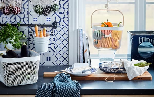 Kitchen worktop with various food produce kept in hanging and standing containers, like KUNGSFORS nets and RISATORP baskets