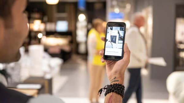 Kunde nutzt die IKEA App während seines Einkaufs im Einrichtungshaus.