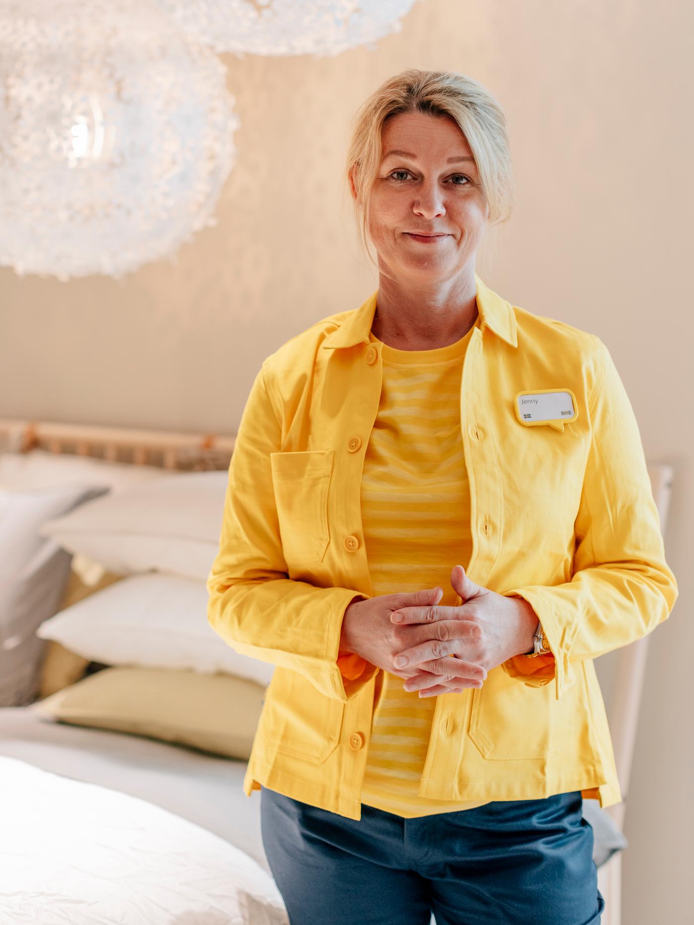 Kvinna i gula IKEA-kläder i heminredningsmiljö.